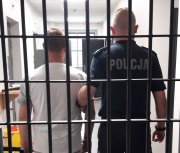 Mężczyzna, który dopuścił się paserstwa znajduje się w pomieszczeniu dla osób zatrzymanych. Jest pilnowany przez policjanta - profosa z KPP w Poddębicach. Oboje znajdują się w pomieszczeniu za metalowymi kratami.