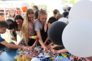 Dzieci pod namiotem policyjnym wybierają sobie upominki m.in. odblaski.